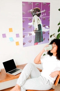 curly hair girl sipping coffee next to big purple poster