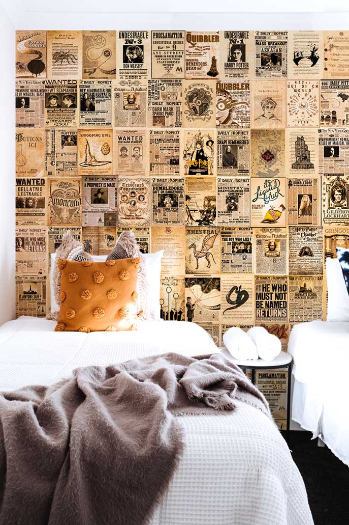 Harry Potter newspaper collage on a wall behind a white bed with throw pillows