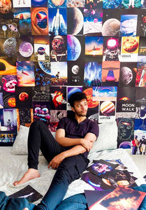 Guy sitting on his bed with space posters collage behind