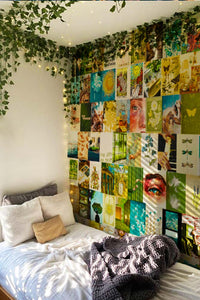 sage green & yellow posters collage next to a narrow bed with green wall vine on top