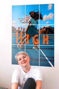 girl smiling in the camera with a big poster on the wall behind