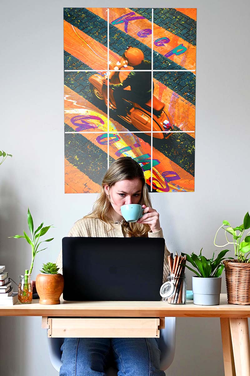 woman working and drinking coffee with 9 set block kit poster on the wall behind