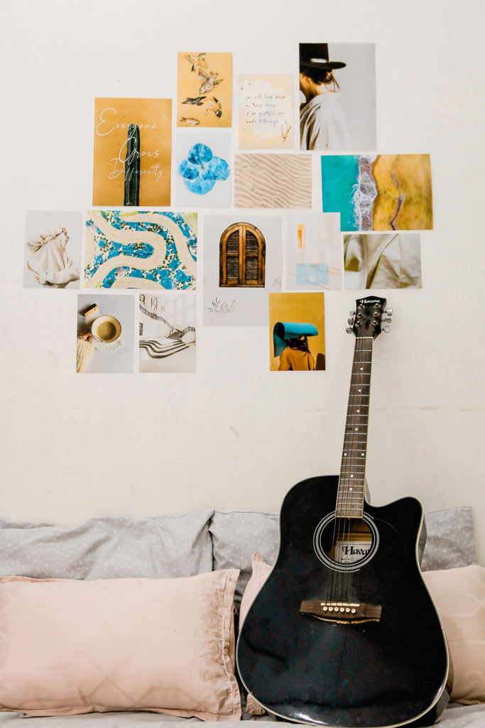 minimal beige mini kit posters on a wall over a bed with pillows and a black guitar