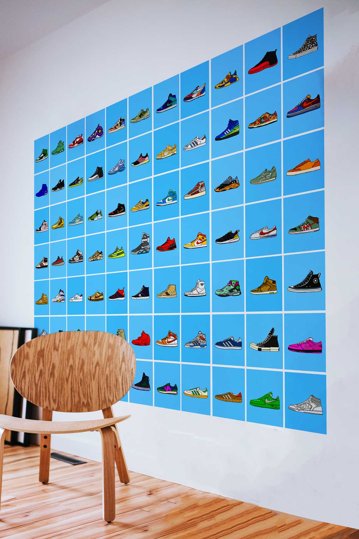 Sneaker collectibles posters collage on a big wall in drawing room next to a big wooden chair